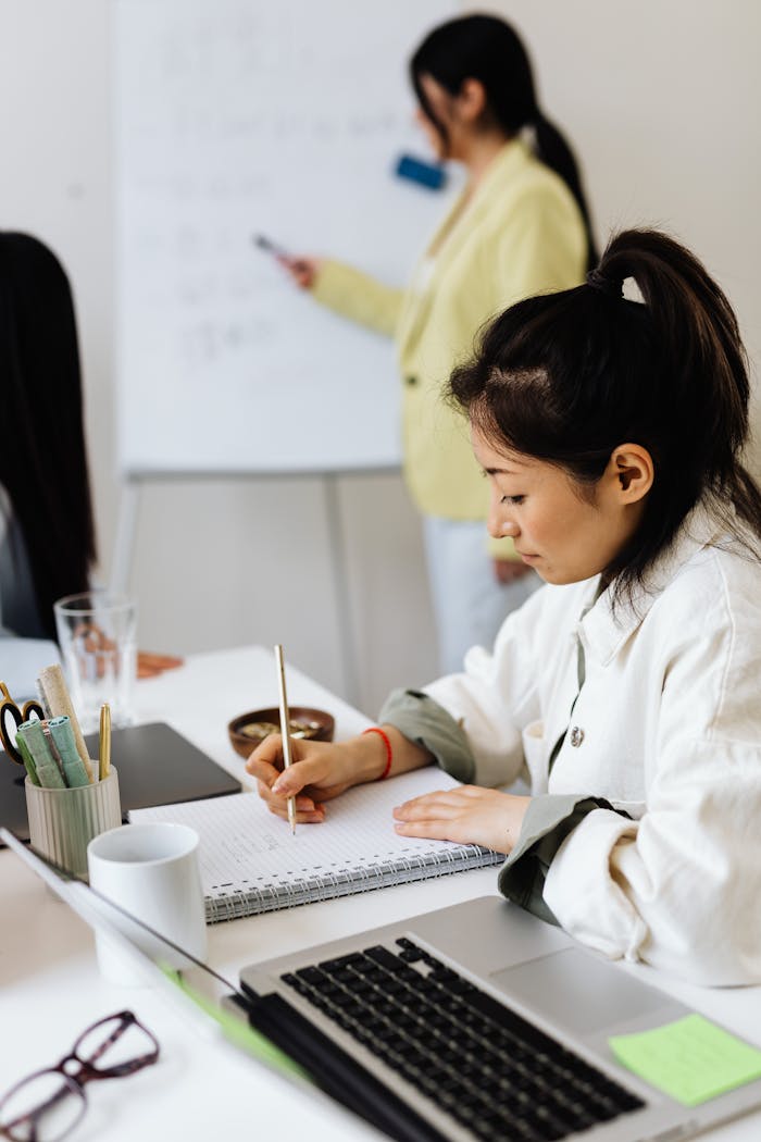 Focused businesswoman taking notes during a team meeting.